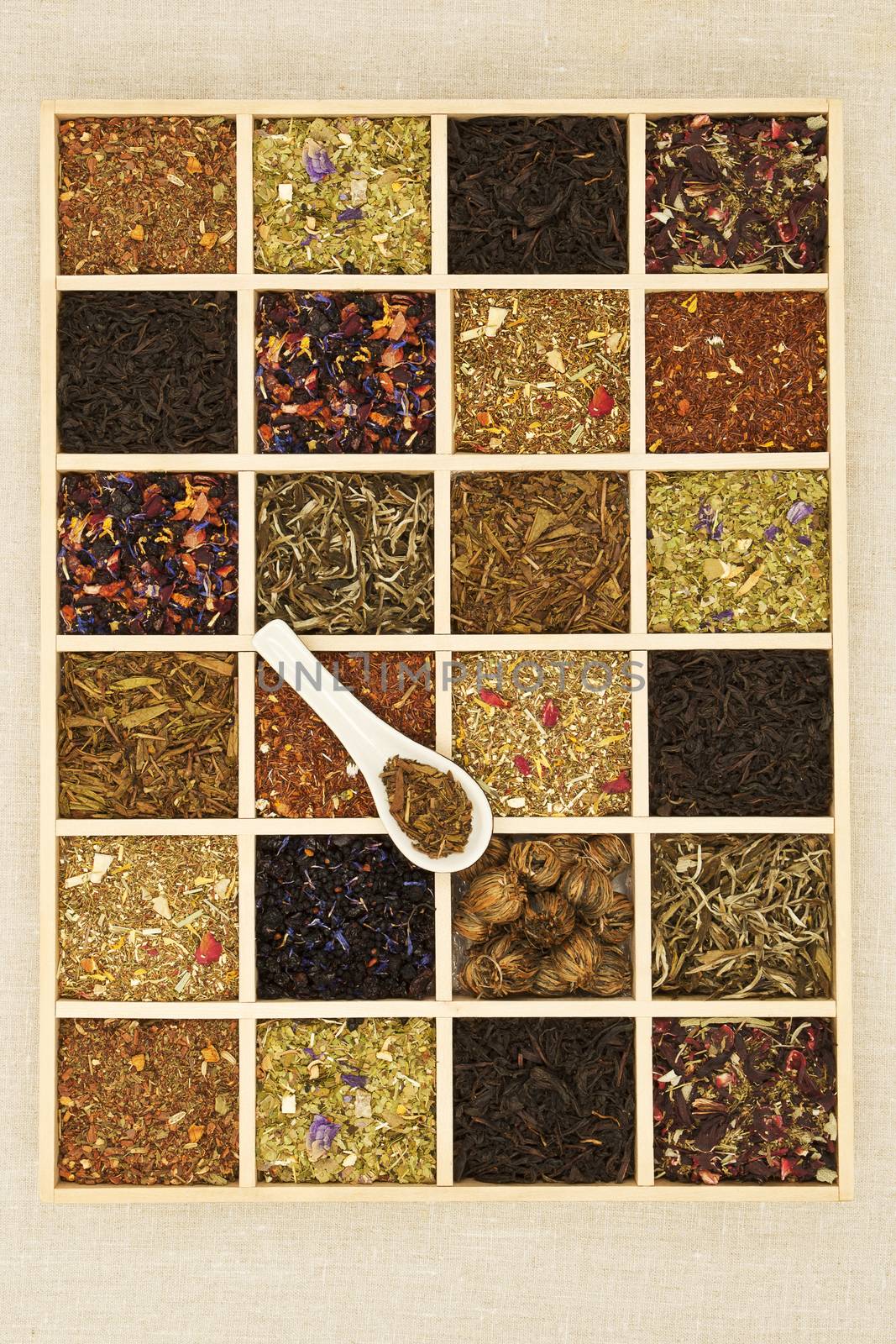 Different tea sorts in wooden box. Dry tea leaf collection. Top view.