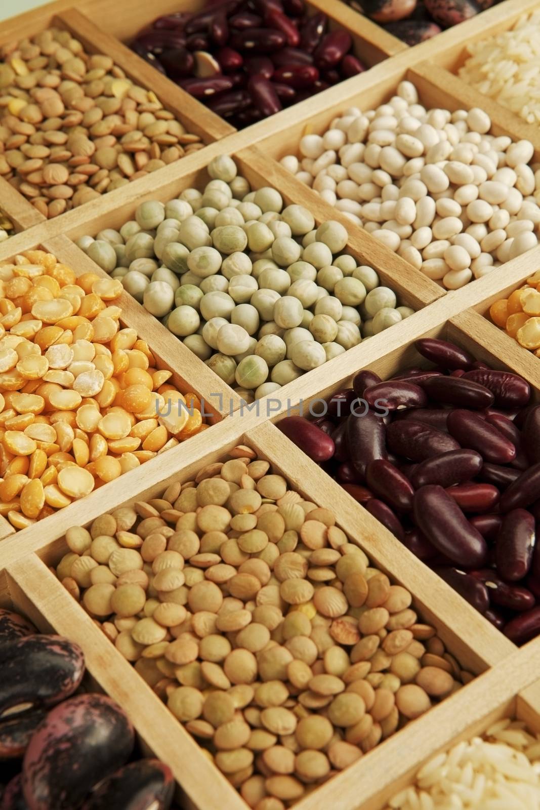 Variation of different beans, lentils and peas in wooden box.