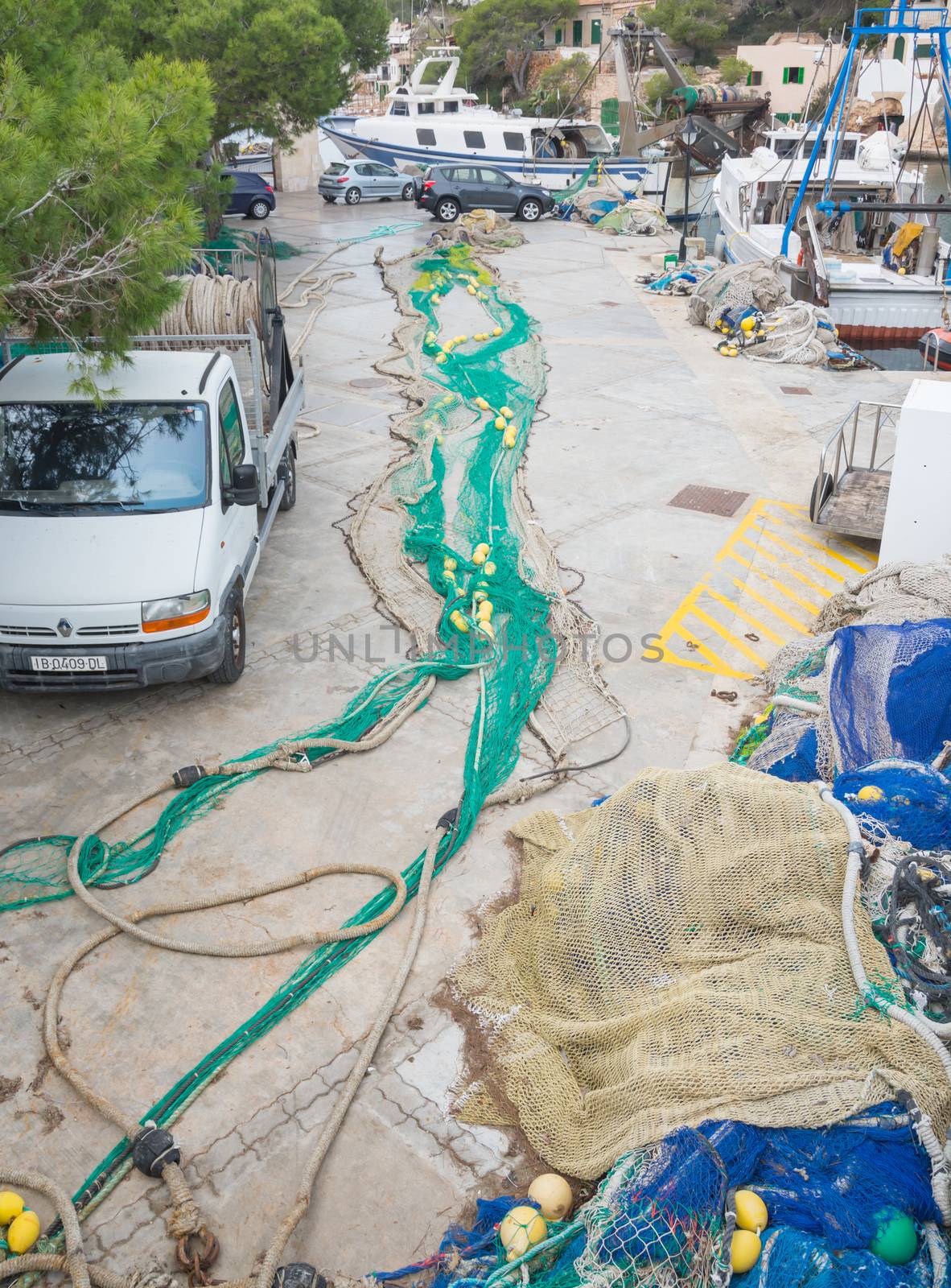 Green fishing nets with yellow buoys on the ground.