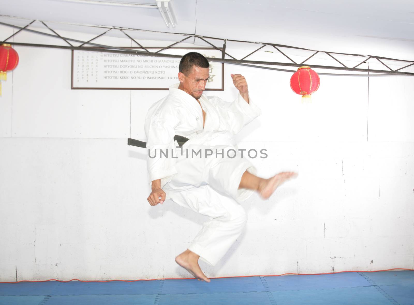 american man in karate suit, suspended in mid air by dacasdo