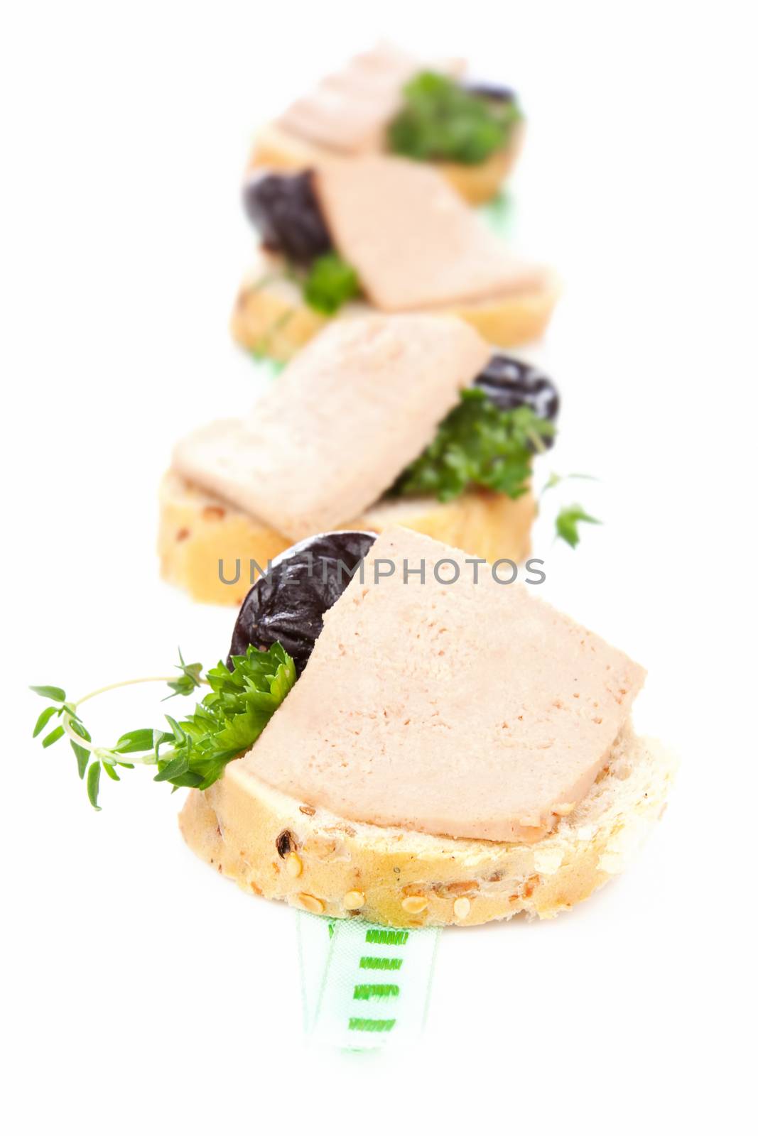 Luxurious culinary eating. White bread with pate, herbs and dried plumb. 