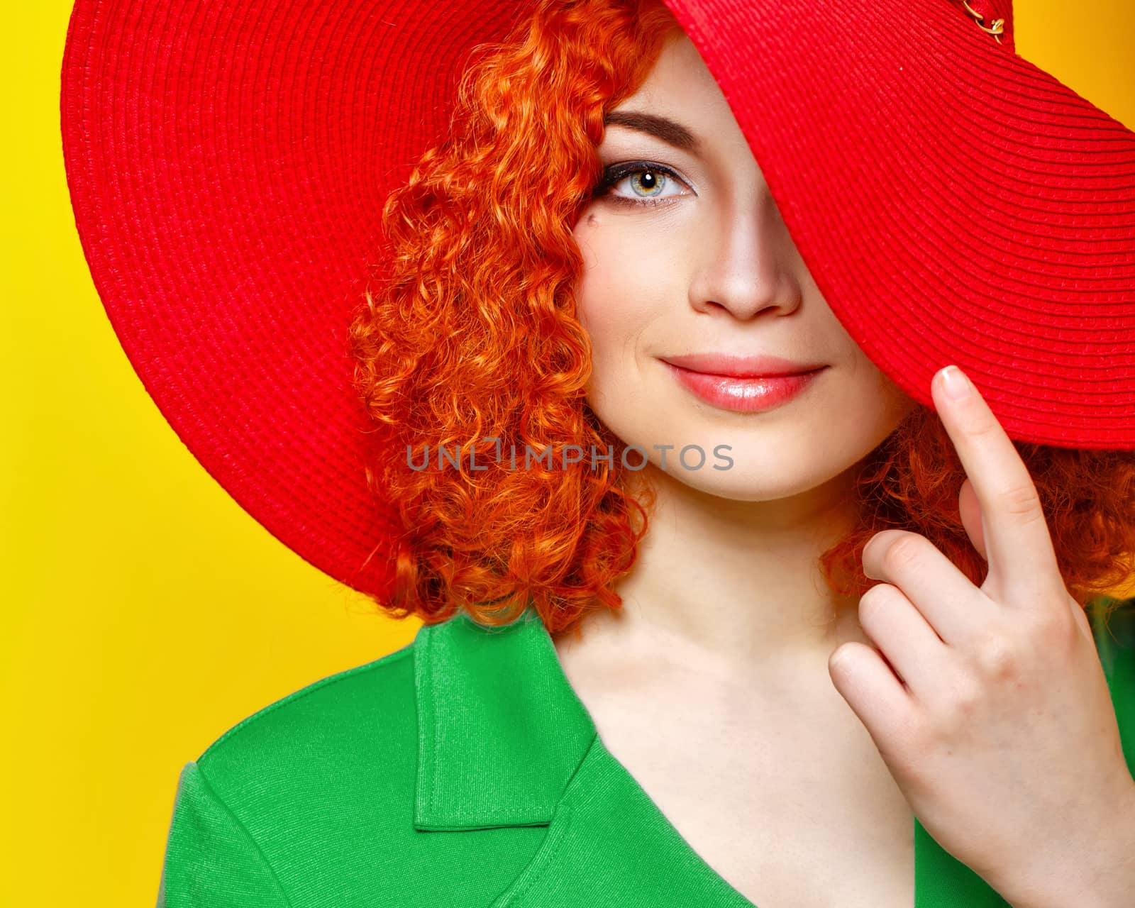 Attractive red-haired girl in red shady hat shot closeup