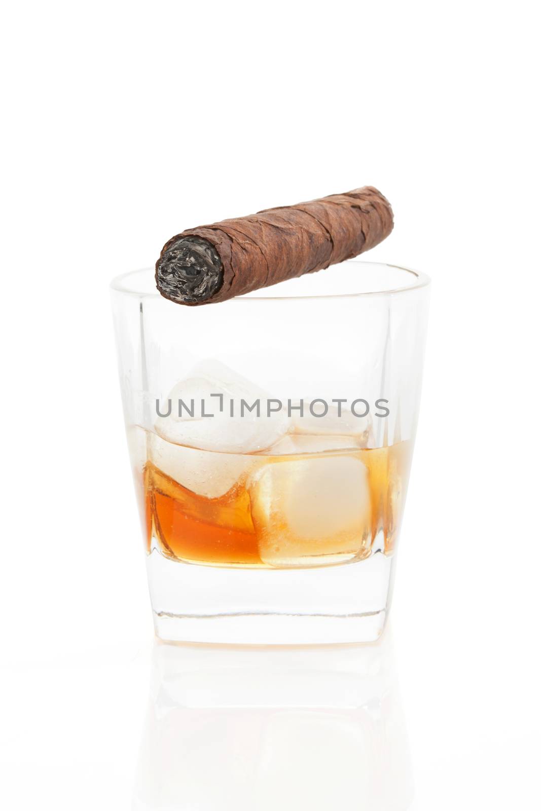 Luxurious cigar on whiskey glass with whiskey and ice isolated on white. Leisure concept.