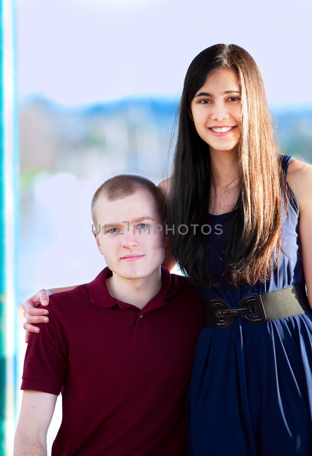 Young woman standing next to seated young man by a lake by jarenwicklund