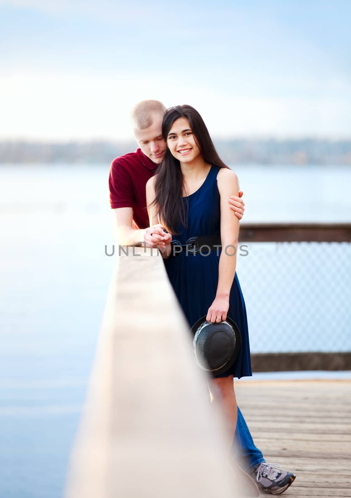 Young interracial couple standing together on wooden pier overlo by jarenwicklund