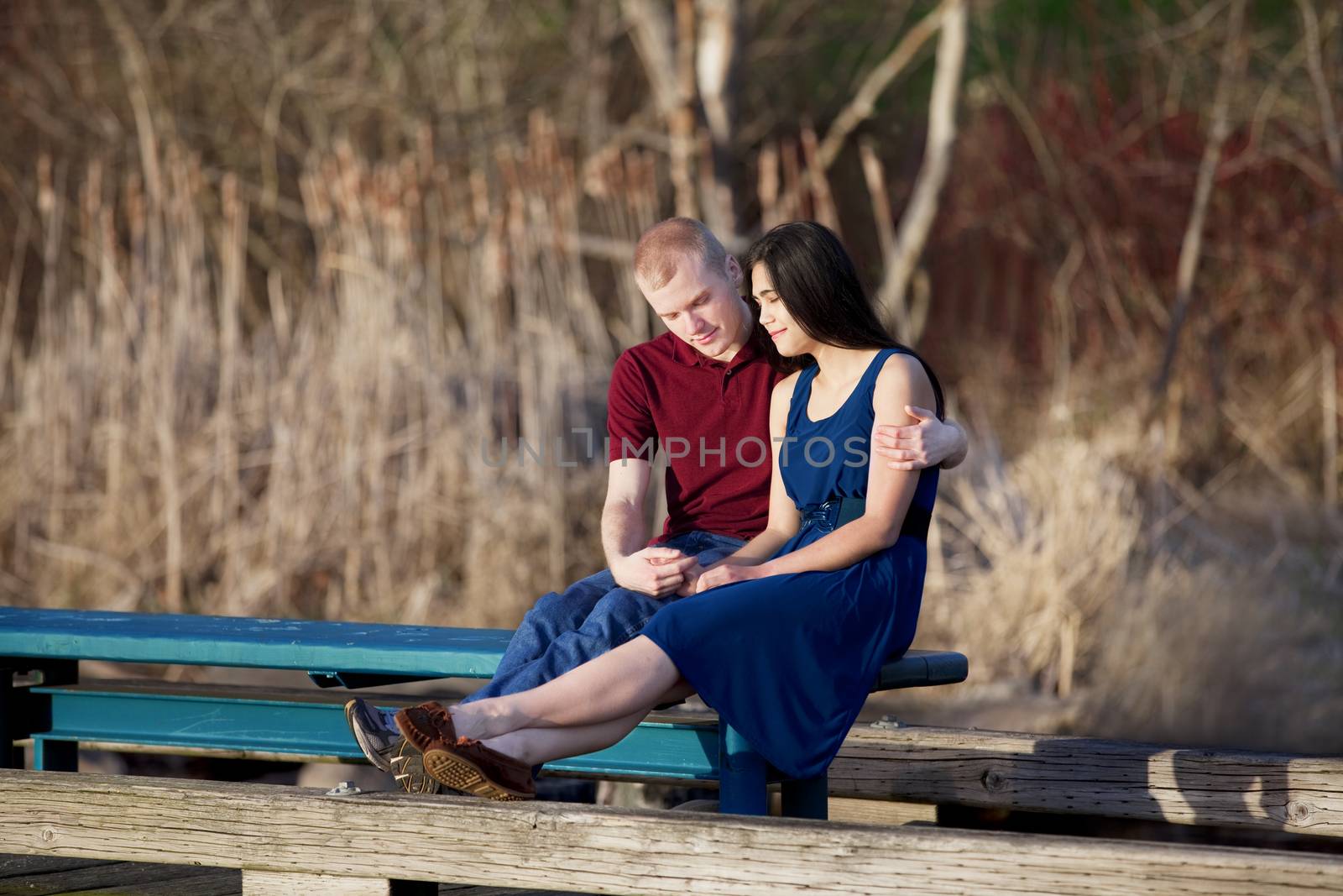 Young interracial couple enjoying time together on wooden pier o by jarenwicklund