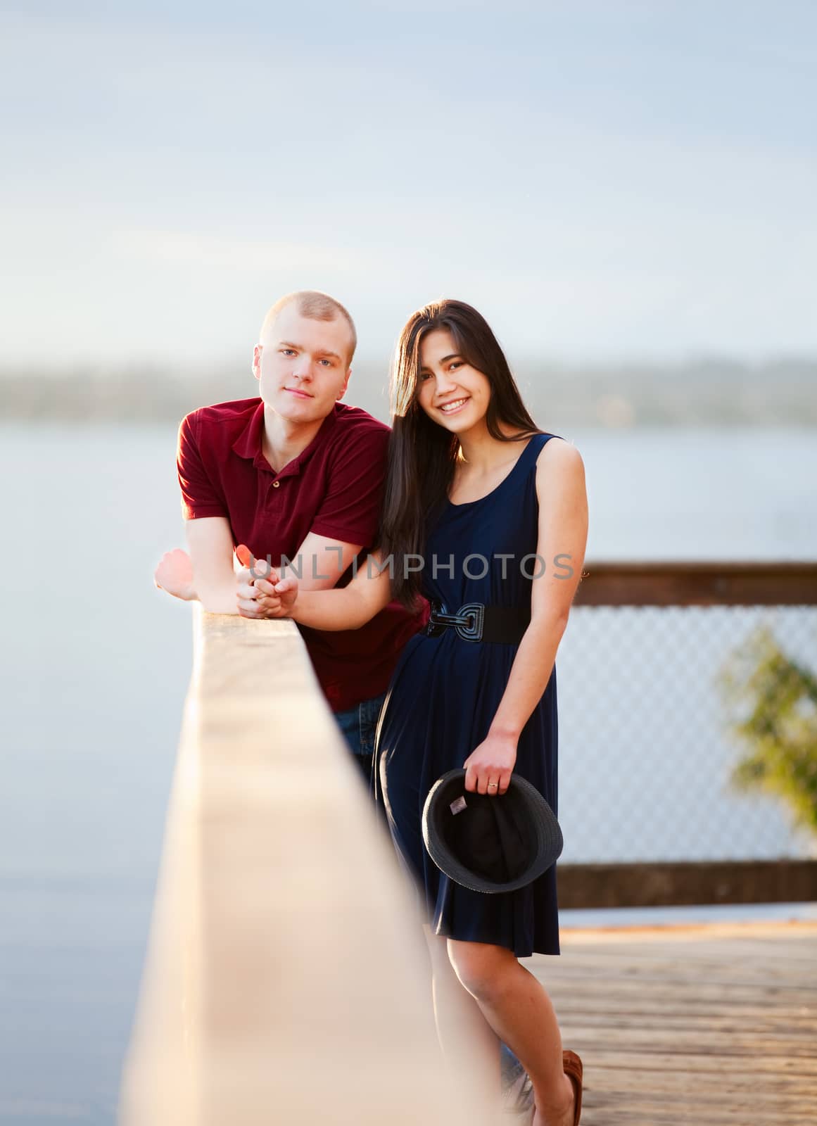 Young interracial couple standing together on wooden pier overlo by jarenwicklund