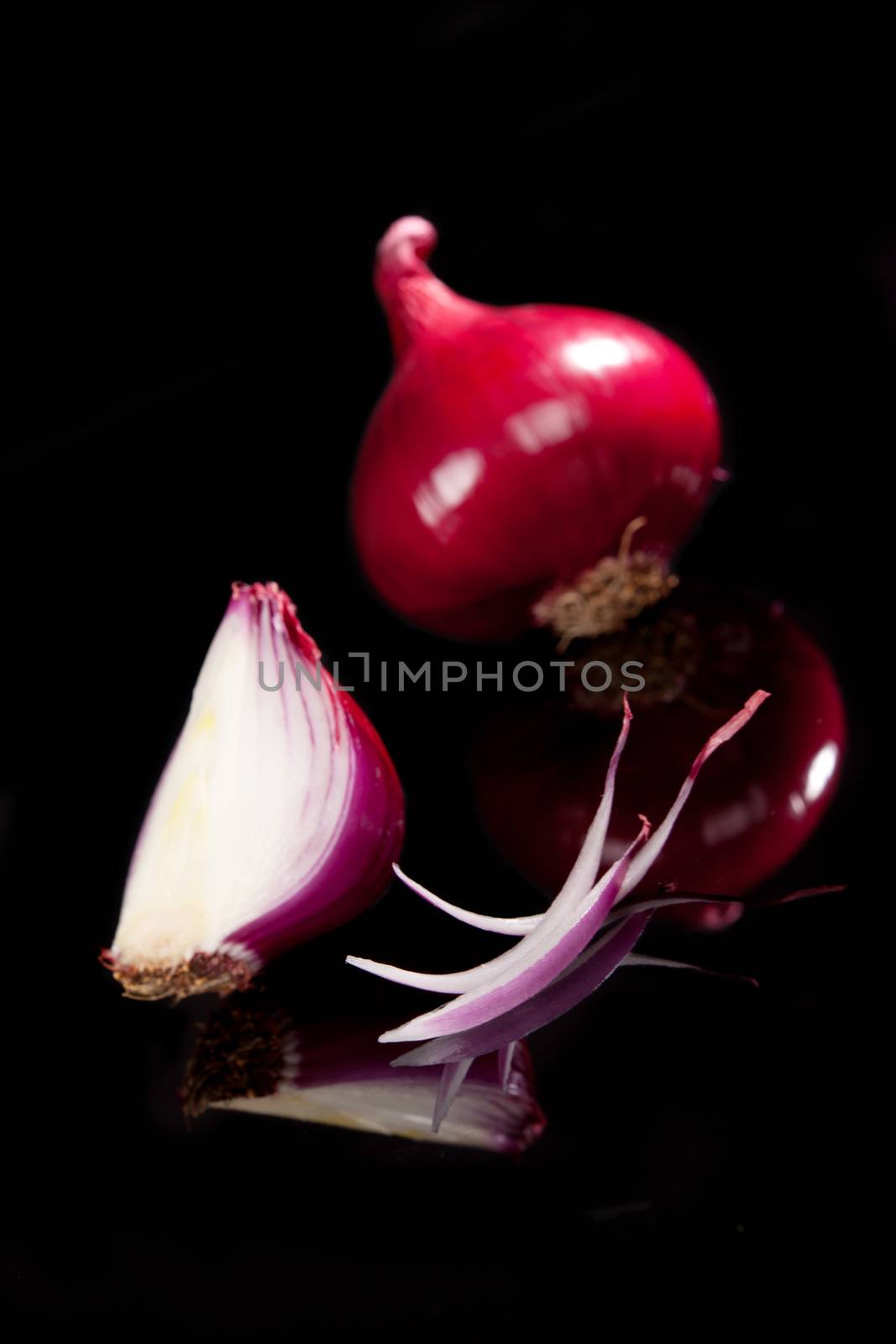 Purple onion slice, half and whole onion isolated on black background. Onion still life.