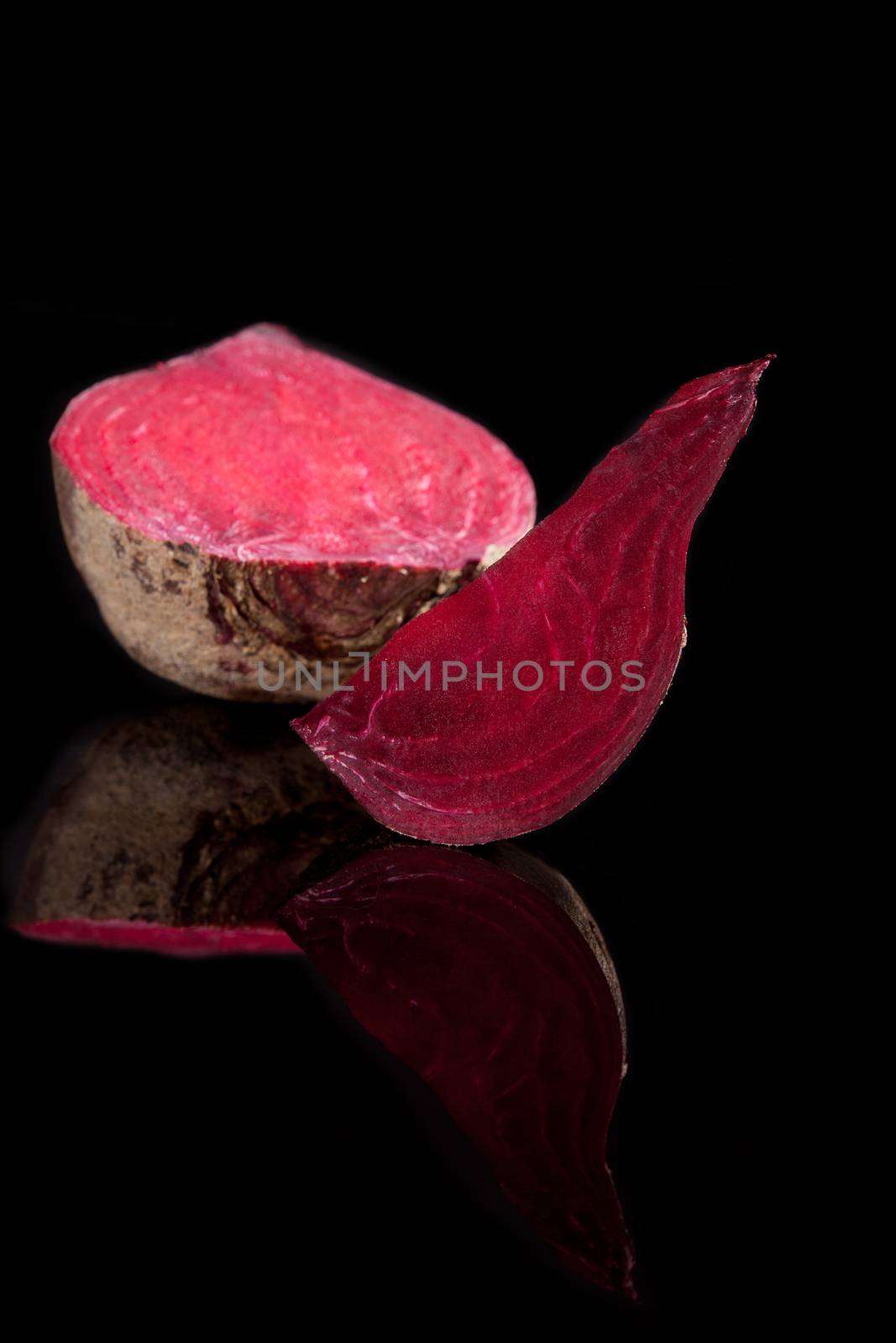 Delicious healthy purple beet isolated on black background with reflection. Luxurious culinary vegetable background.