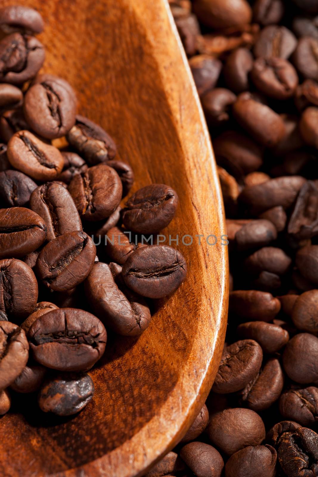 Luxurious coffee background. Coffee beans on wooden spoon detail. Culinary background.