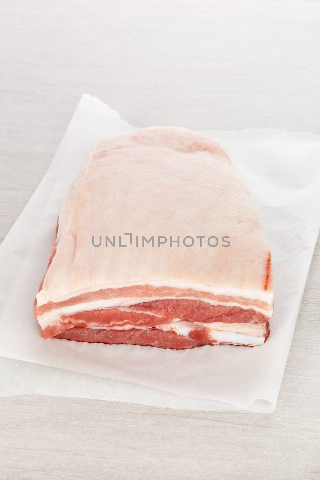 Raw pork belly piece on white background. Culinary meat eating.