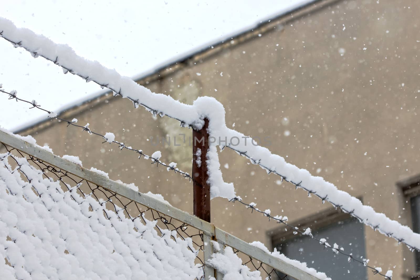  building behind barbed wire snowy cold winter