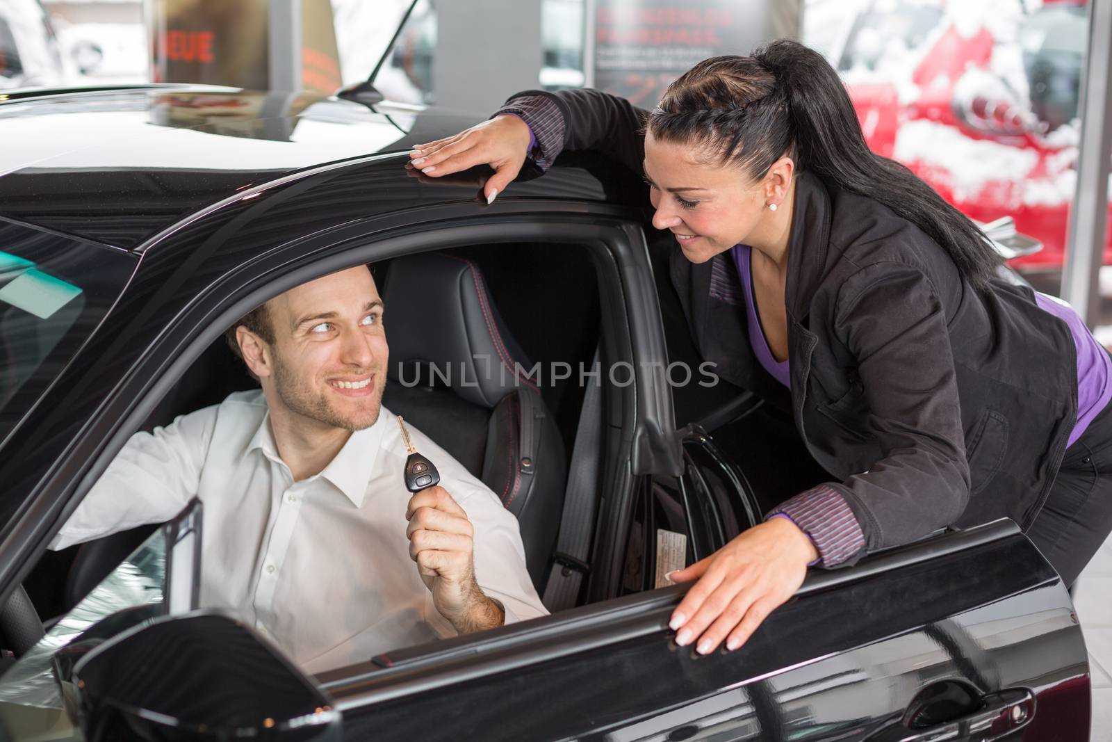 Saleswoman in car dealership selling a automobile