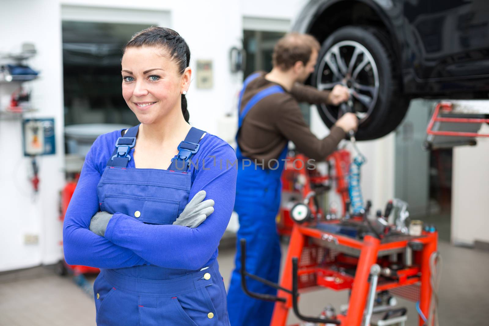 Female mechanic standing in a garage by ikonoklast_fotografie