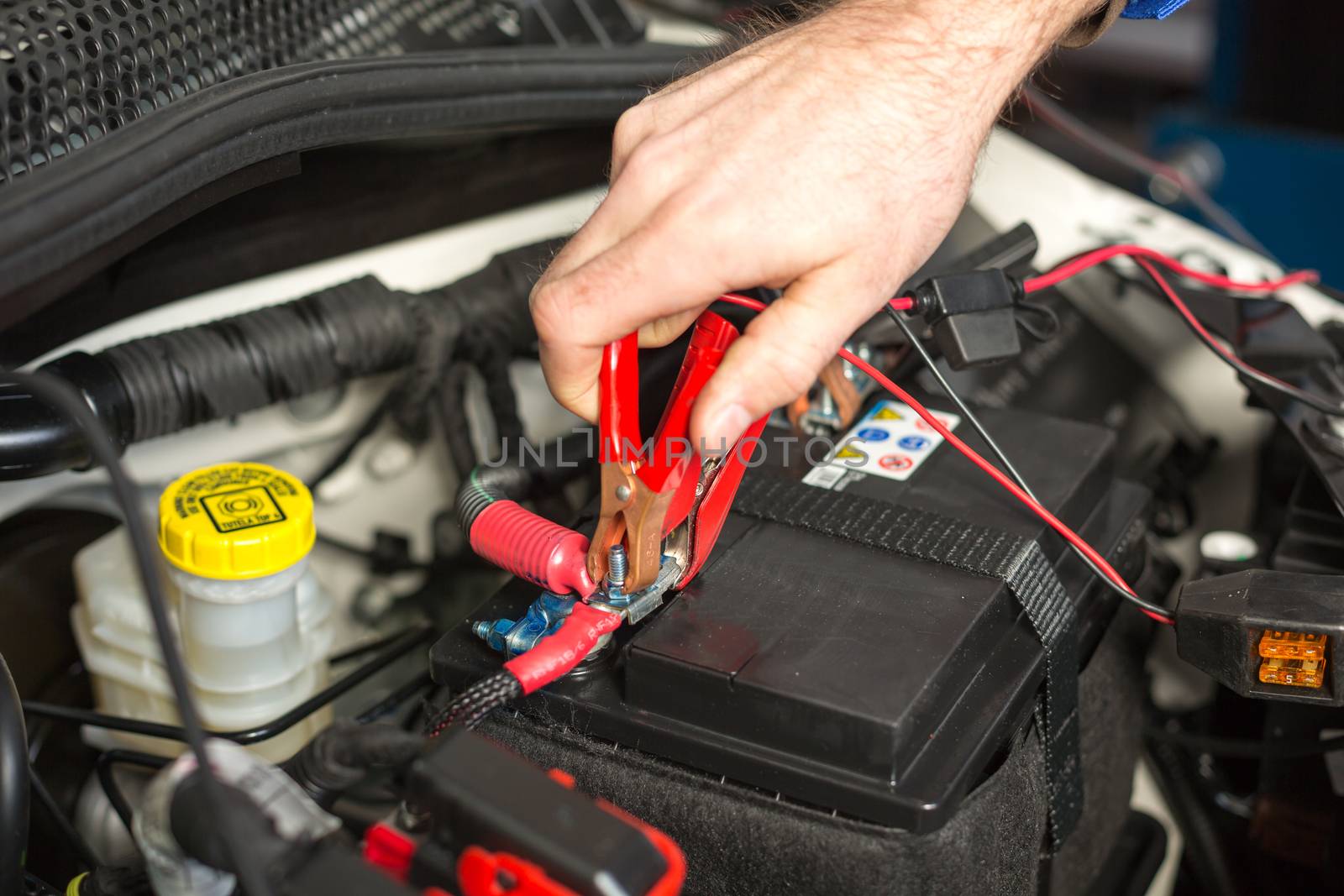 Mechatronic technician working on the battery of a car