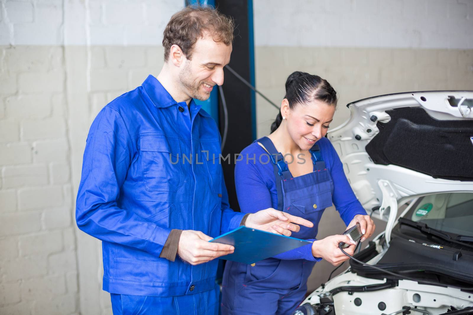 Car mechanics repairing the electrics by ikonoklast_fotografie