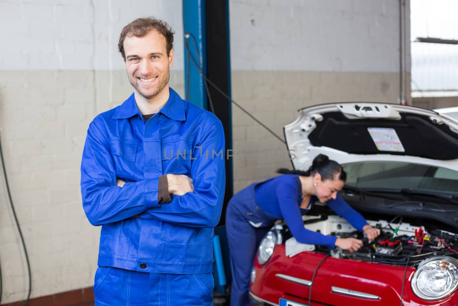 Car mechanic in garage or workshop by ikonoklast_fotografie