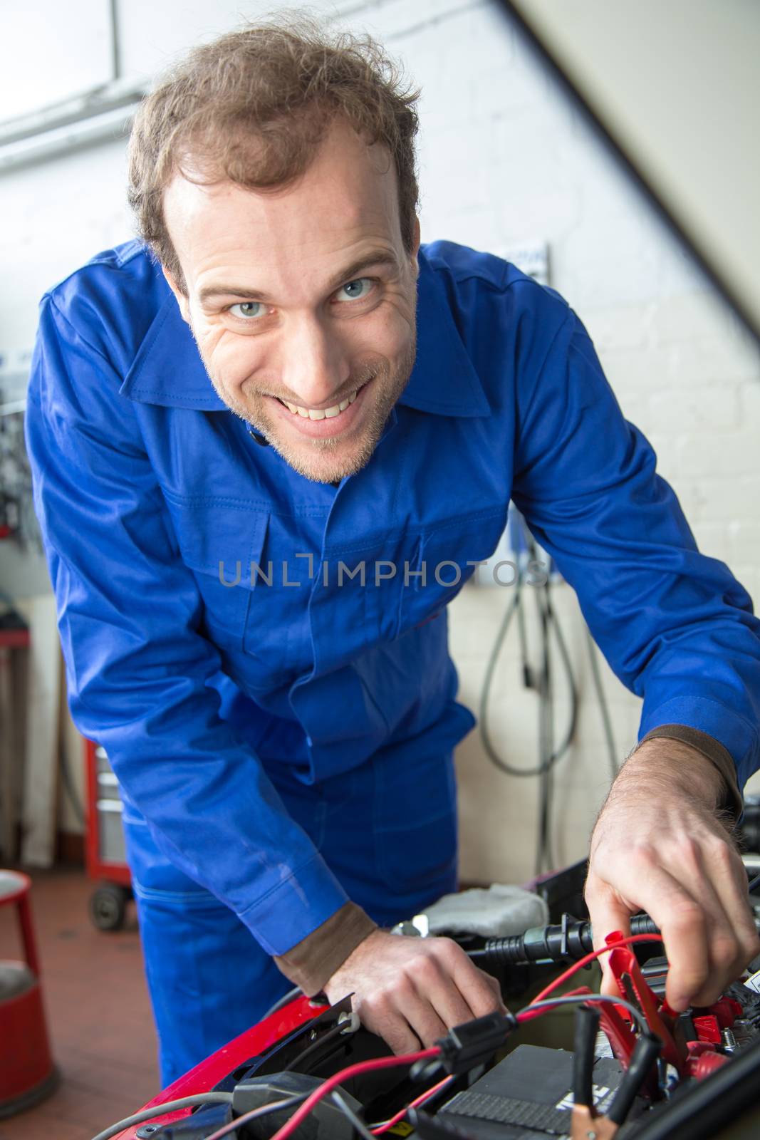 Car mechanic repairing a automobile in a garage or workshop