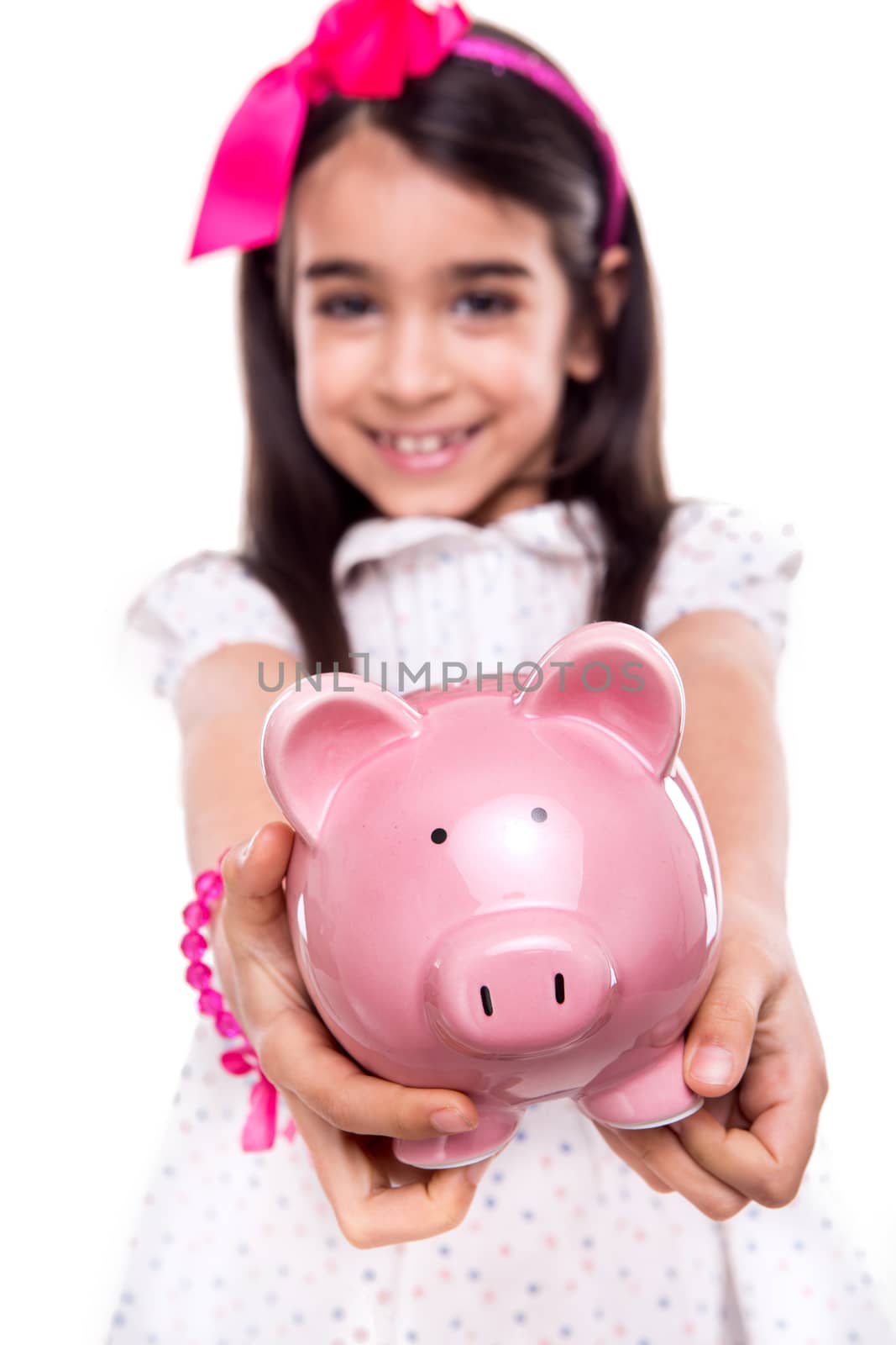 Young girl holding a piggy bank over white background - Selective focus on piggy bank
