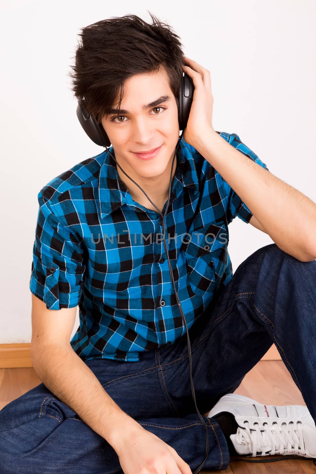 Young man listening music with headphones at home