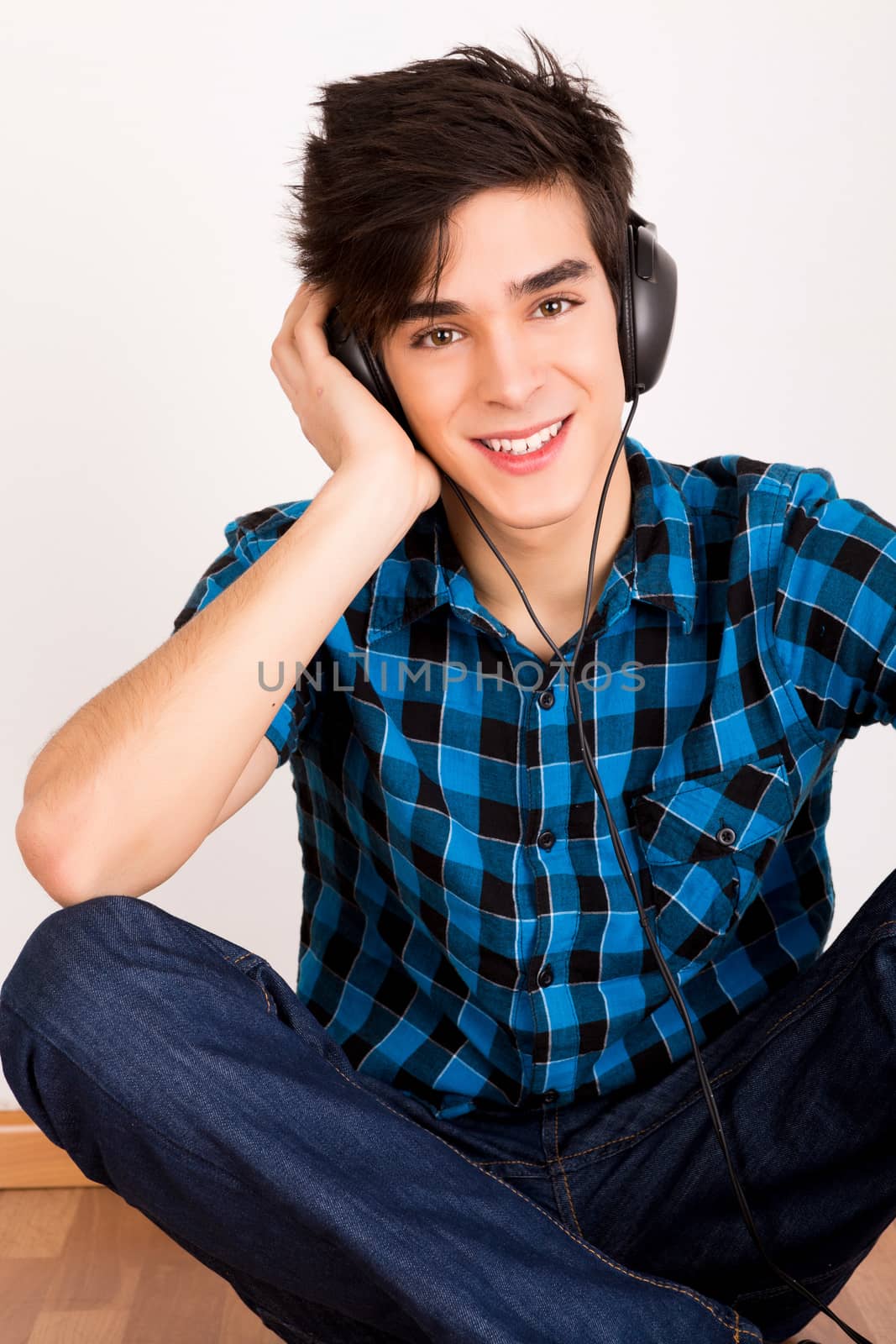 Young man listening music with headphones at home