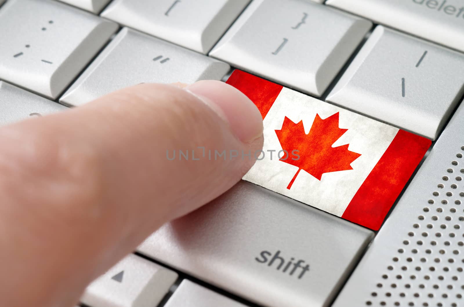 Business concept male finger pressing Canada enter key on metallic keyboard