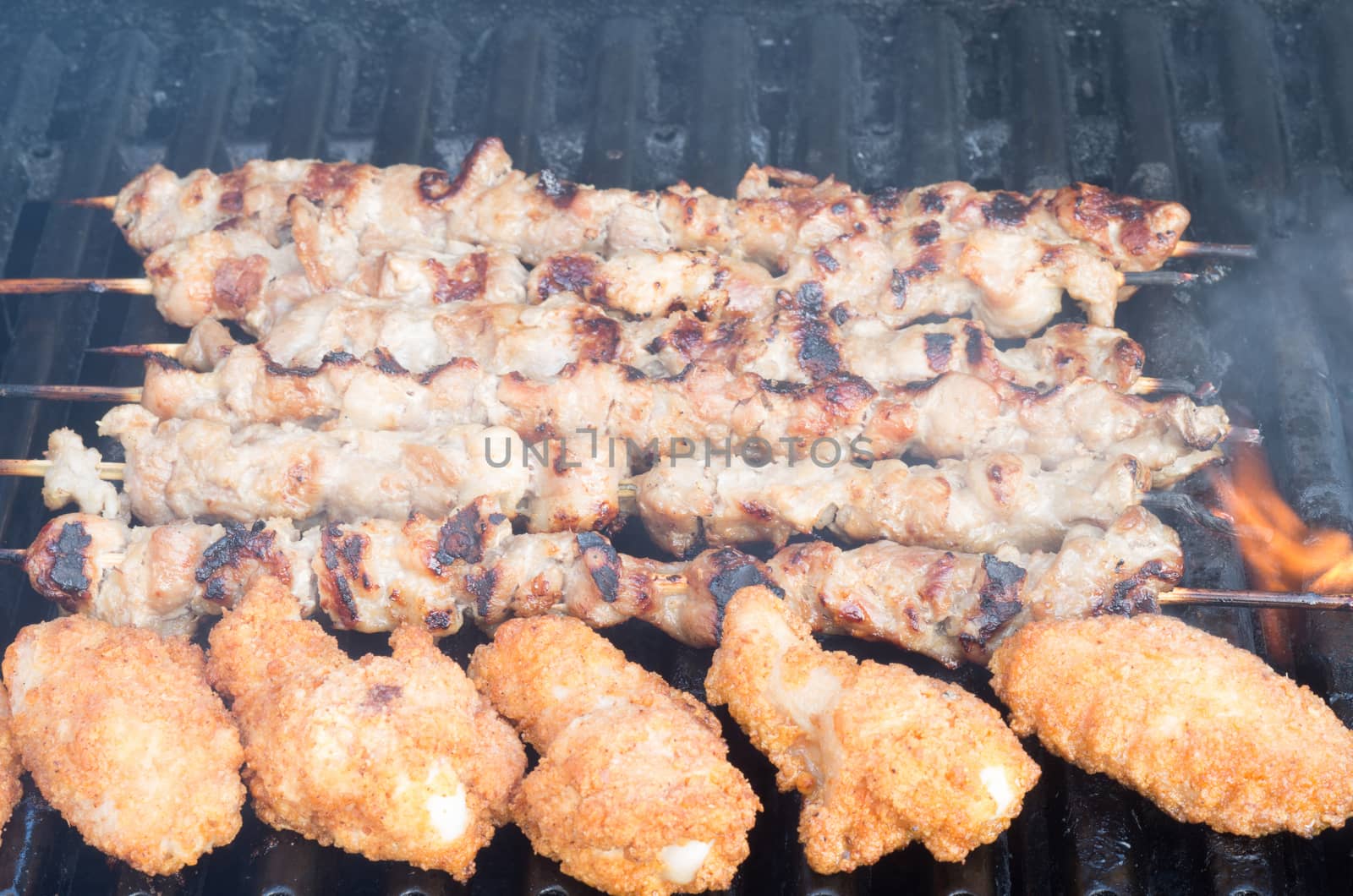Porc skewers and chicken wings on grill by daoleduc