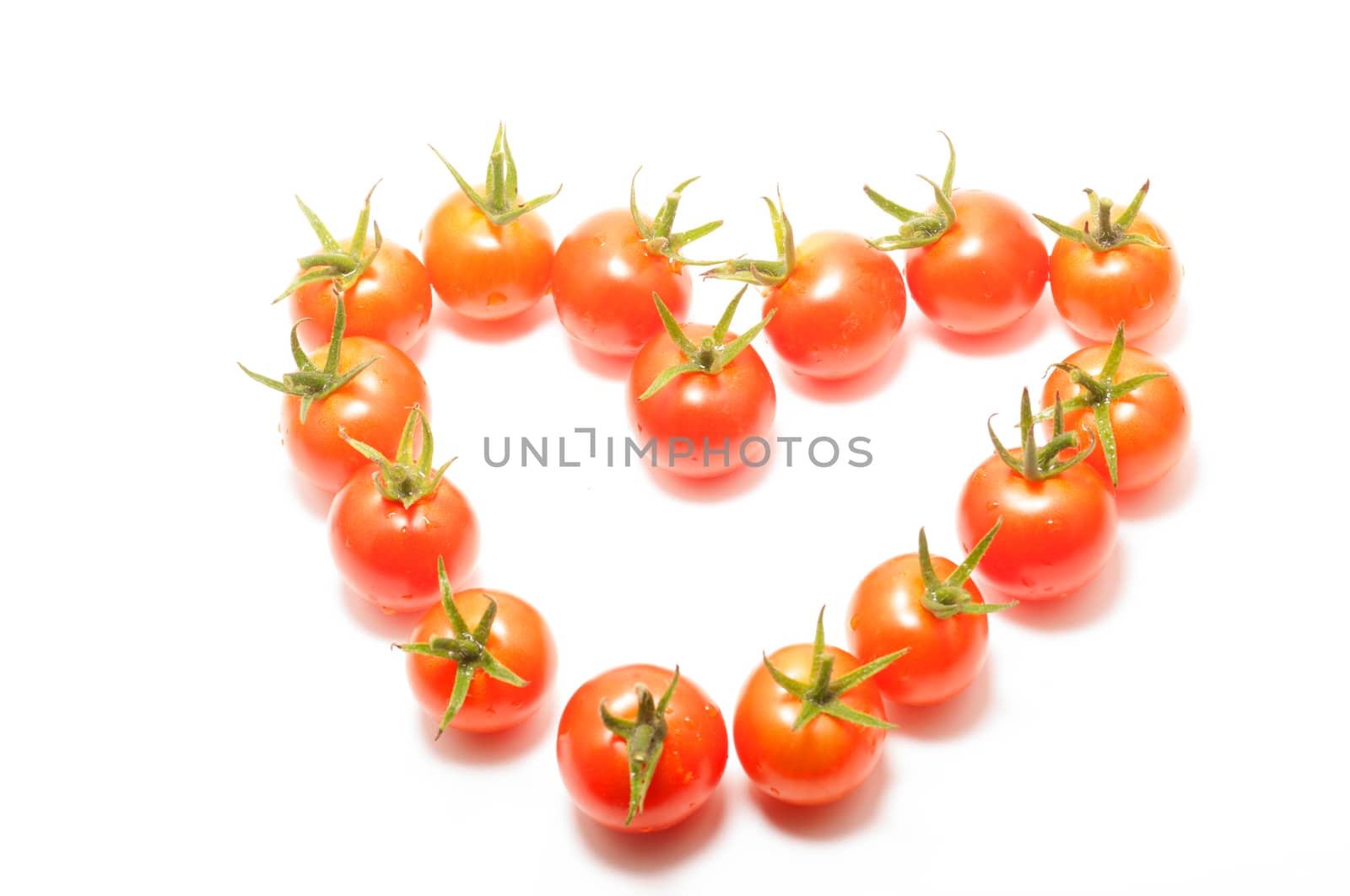 Cherry tomatoes heart shape on white background