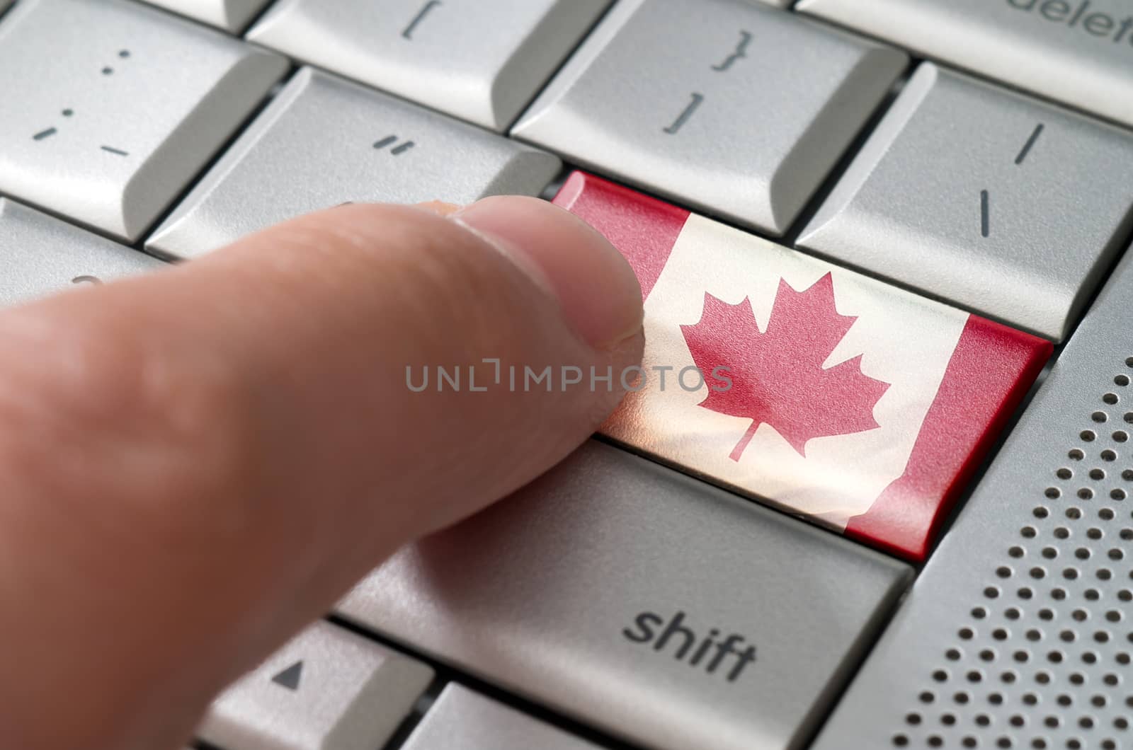 Business concept male finger pressing Canada enter key on metallic keyboard
