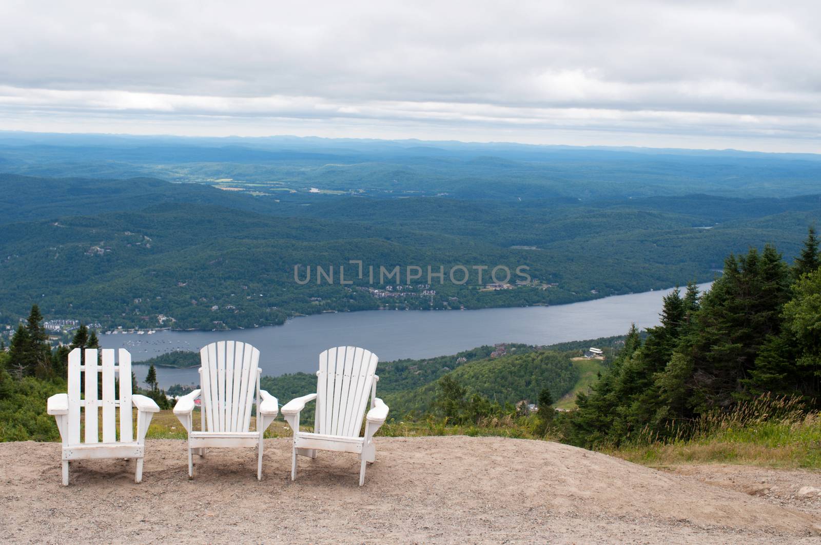 Chairs on top of mountain  at a ski resort during summer time depicting relaxing concept