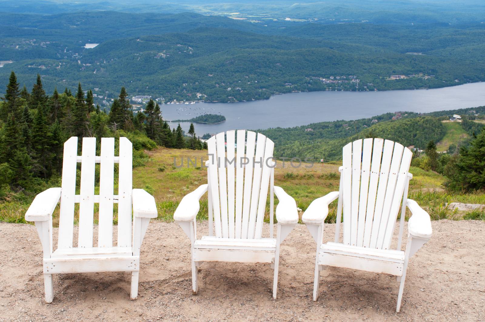 Chairs on top of mountain  at a ski resort during summer time depicting relaxing concept