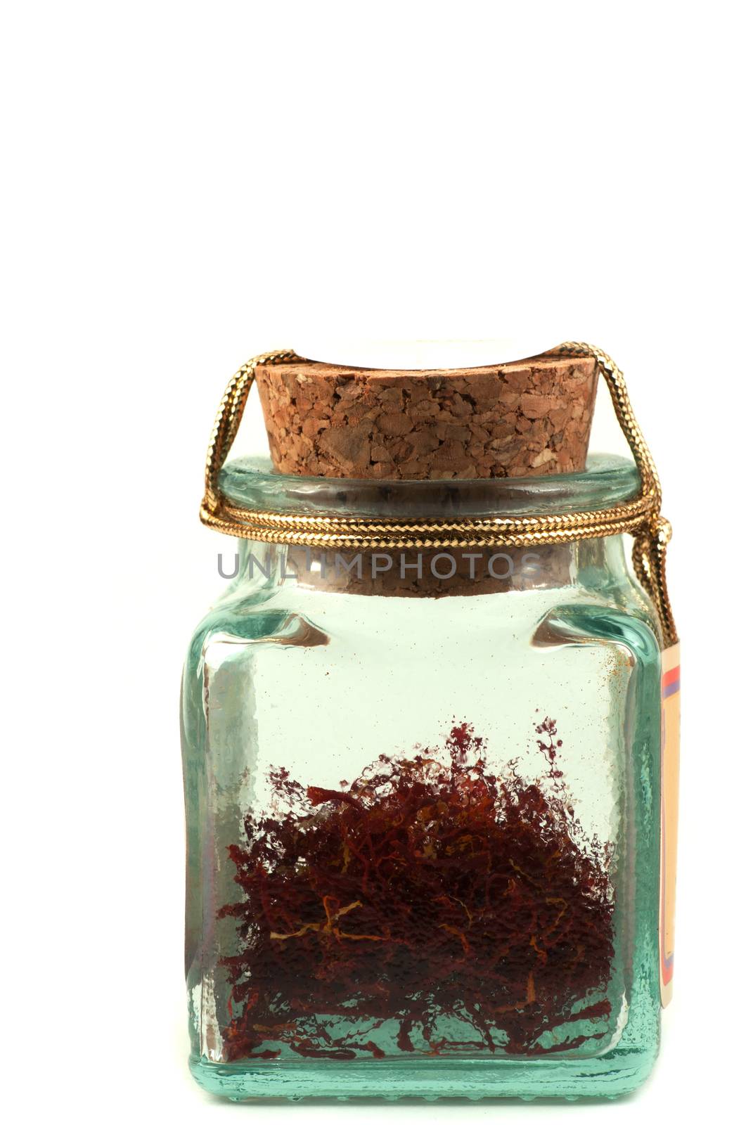 Safran in a glass jar on white background