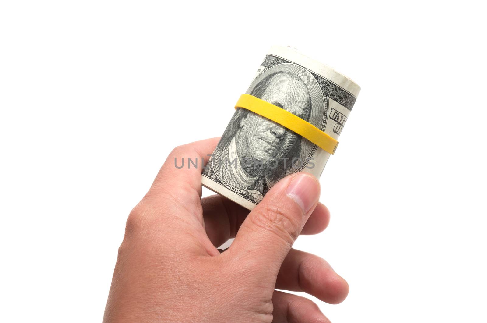 Roll of us bank notes with 100 dollars at the surface, yellow rubber band over the eyes