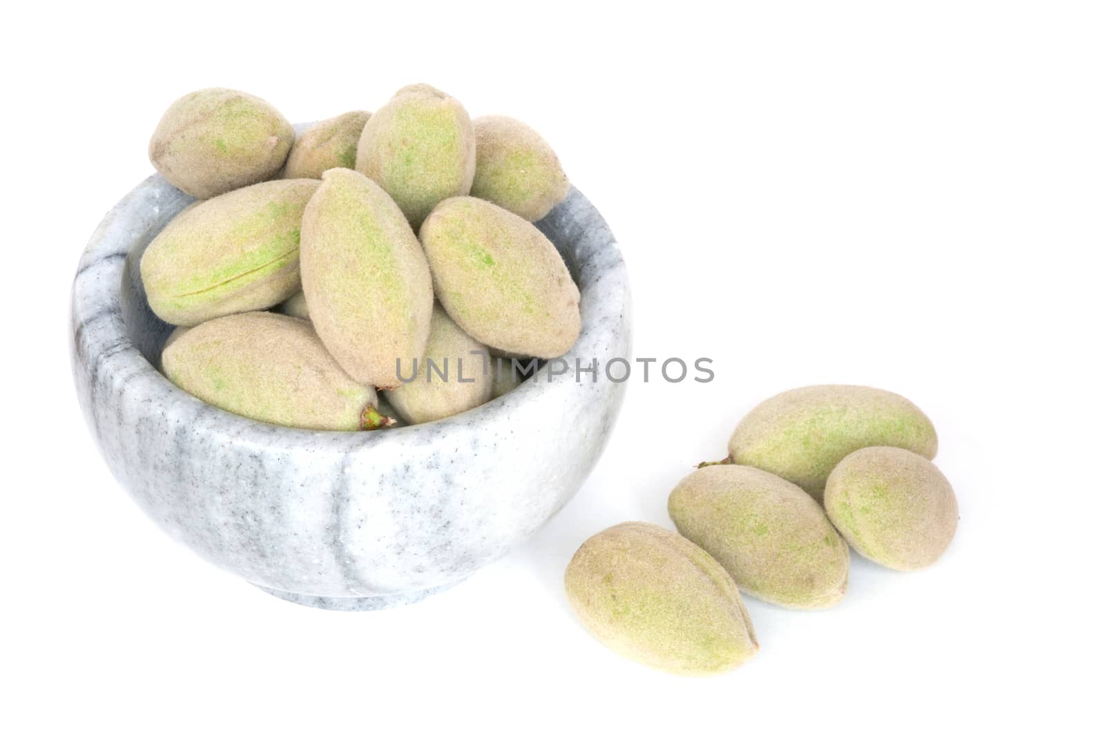 Fresh green almonds in a stone bowl