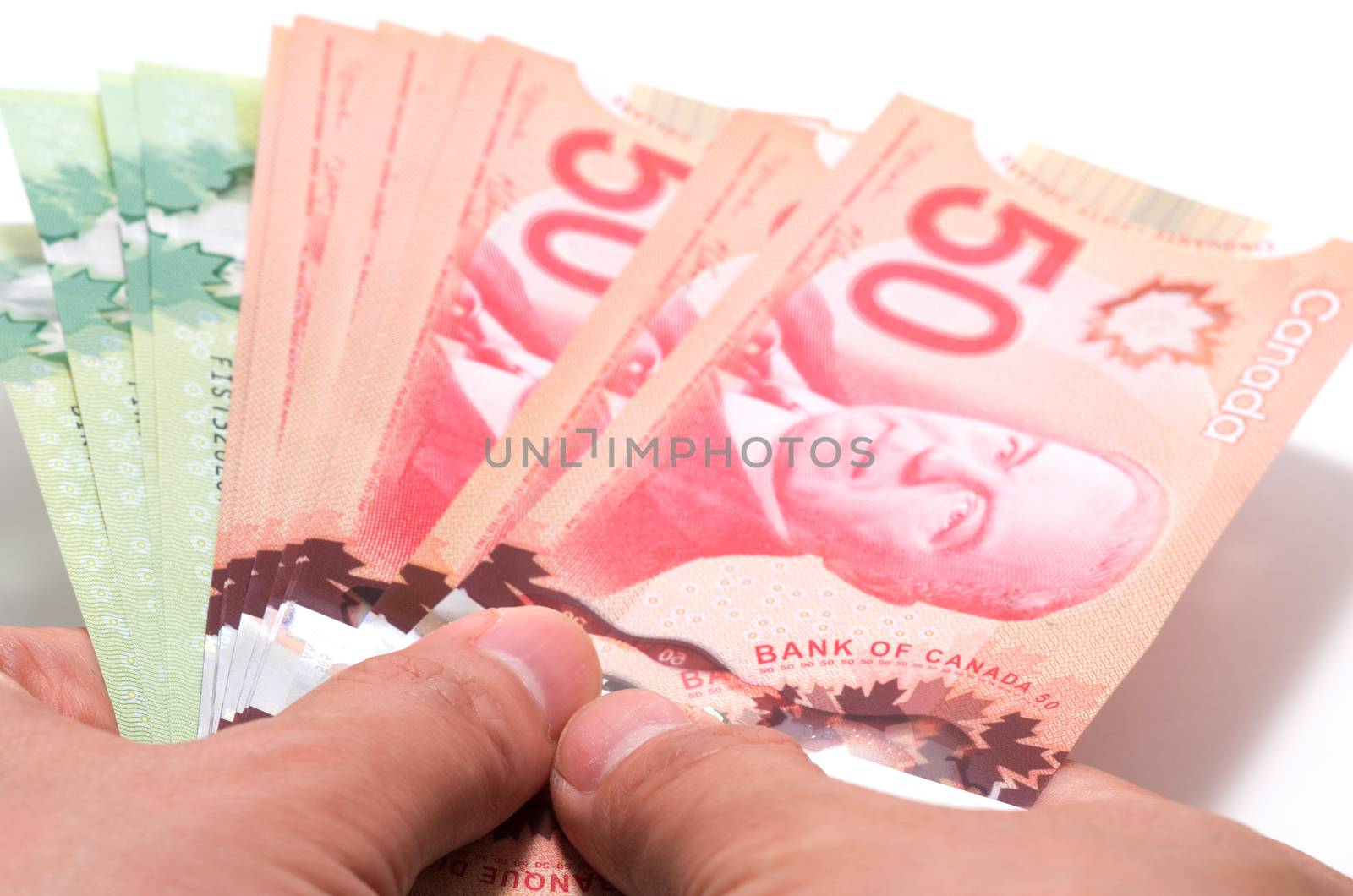 Hand holding a series of Canadian banknotes by daoleduc
