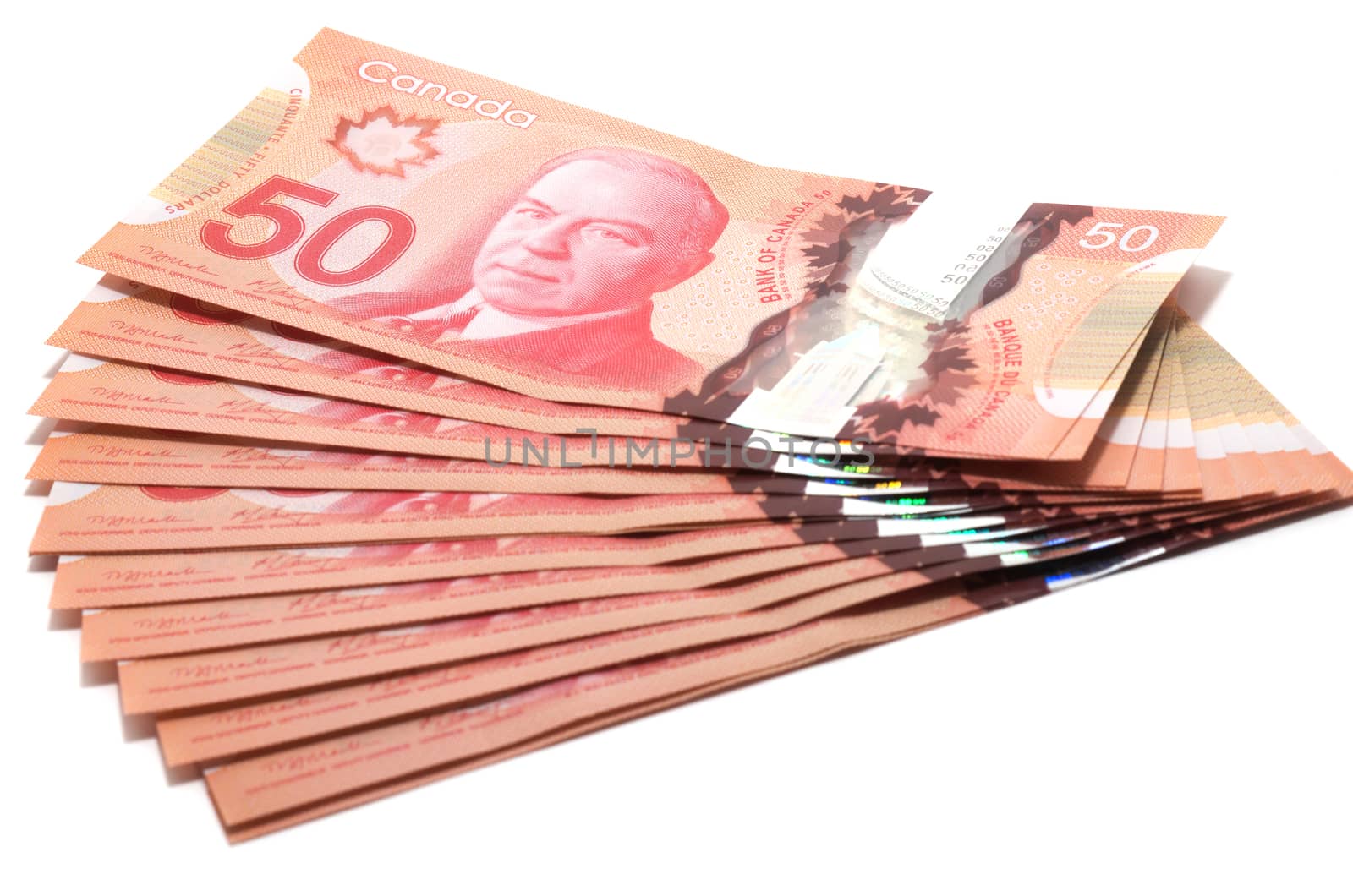 Selective focus of a series of 50 Canadian dollars on white background