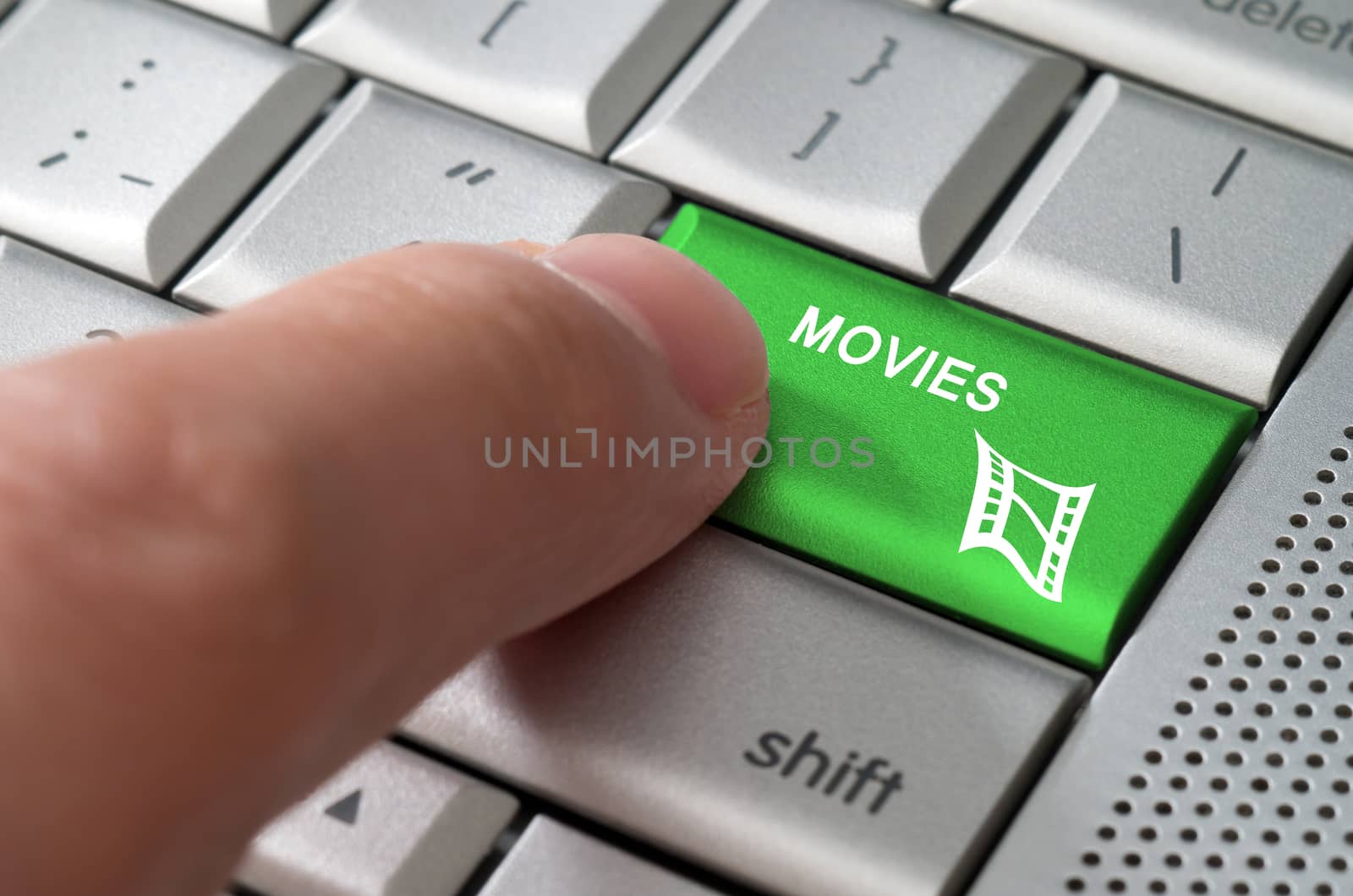Business concept male finger pointing movies key on  a metallic keyboard
