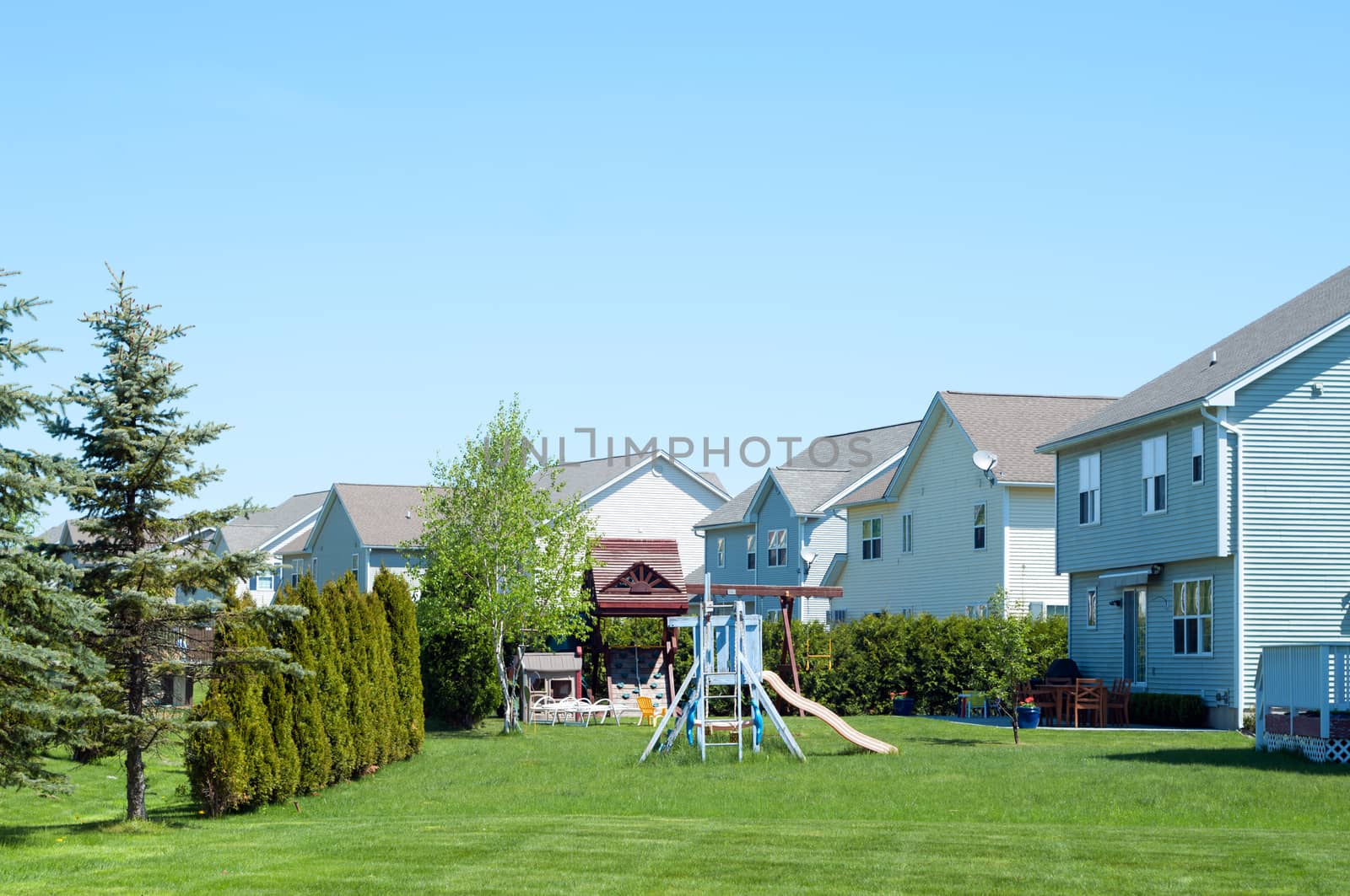 A typical American backyard with child playground during a sunny day
