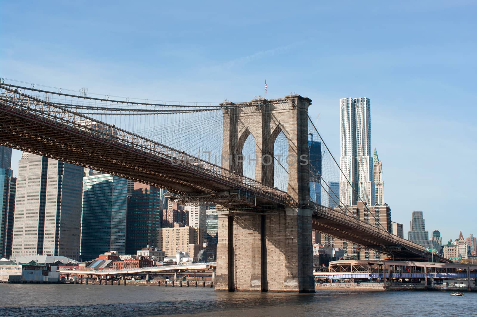 Brooklyn bridge with Manhattan cityscape behind during a sunny day