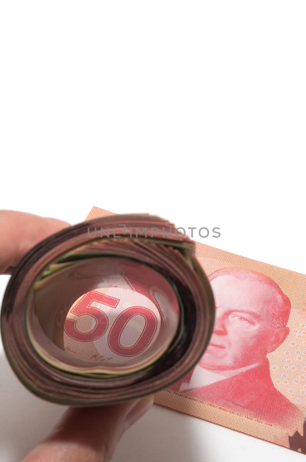 A roll of bank notes focusing on a 50 Canadian dollars by daoleduc