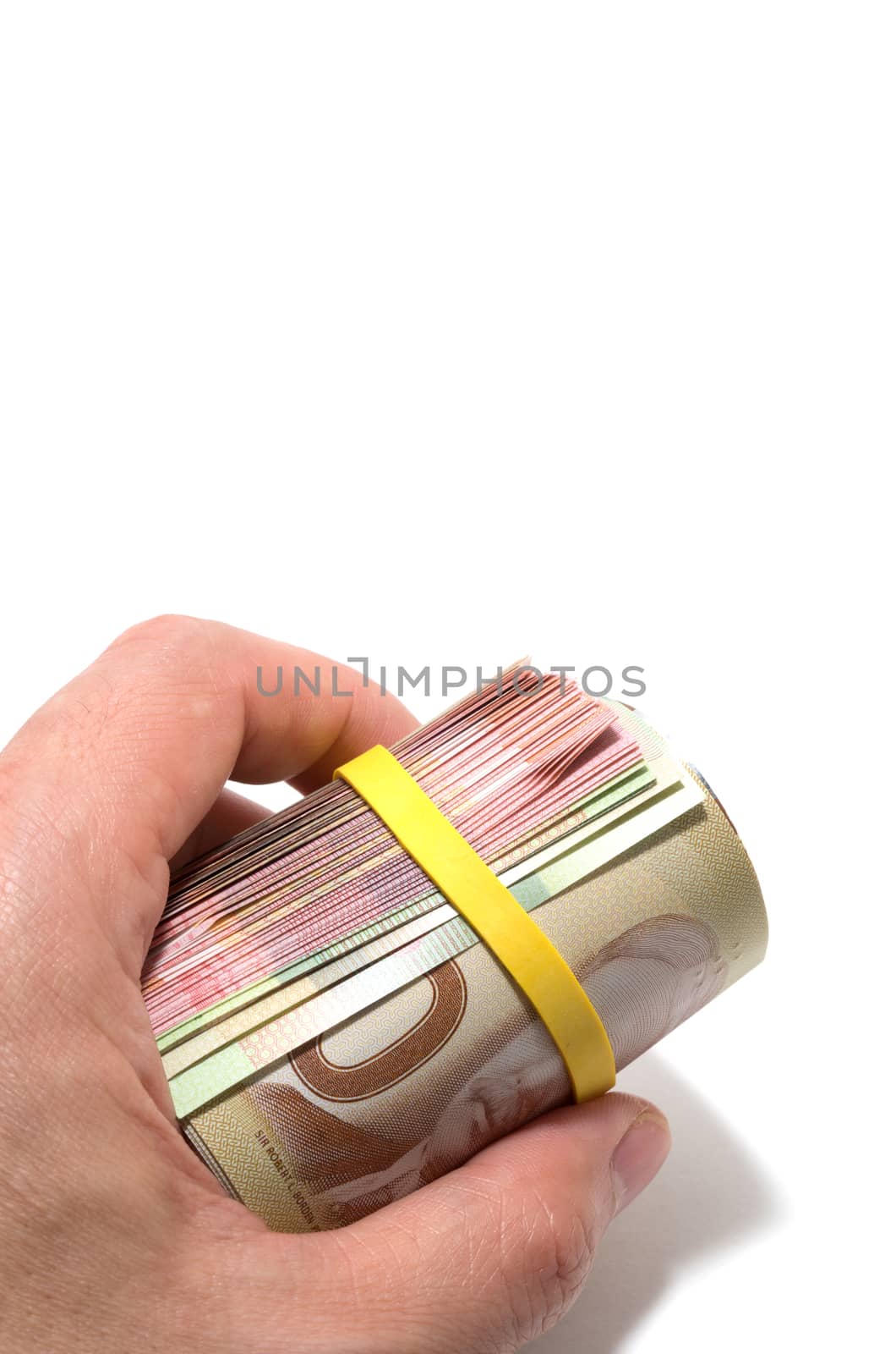 Hand holding a roll of 50 dollars Canadian with yellow plastic b by daoleduc