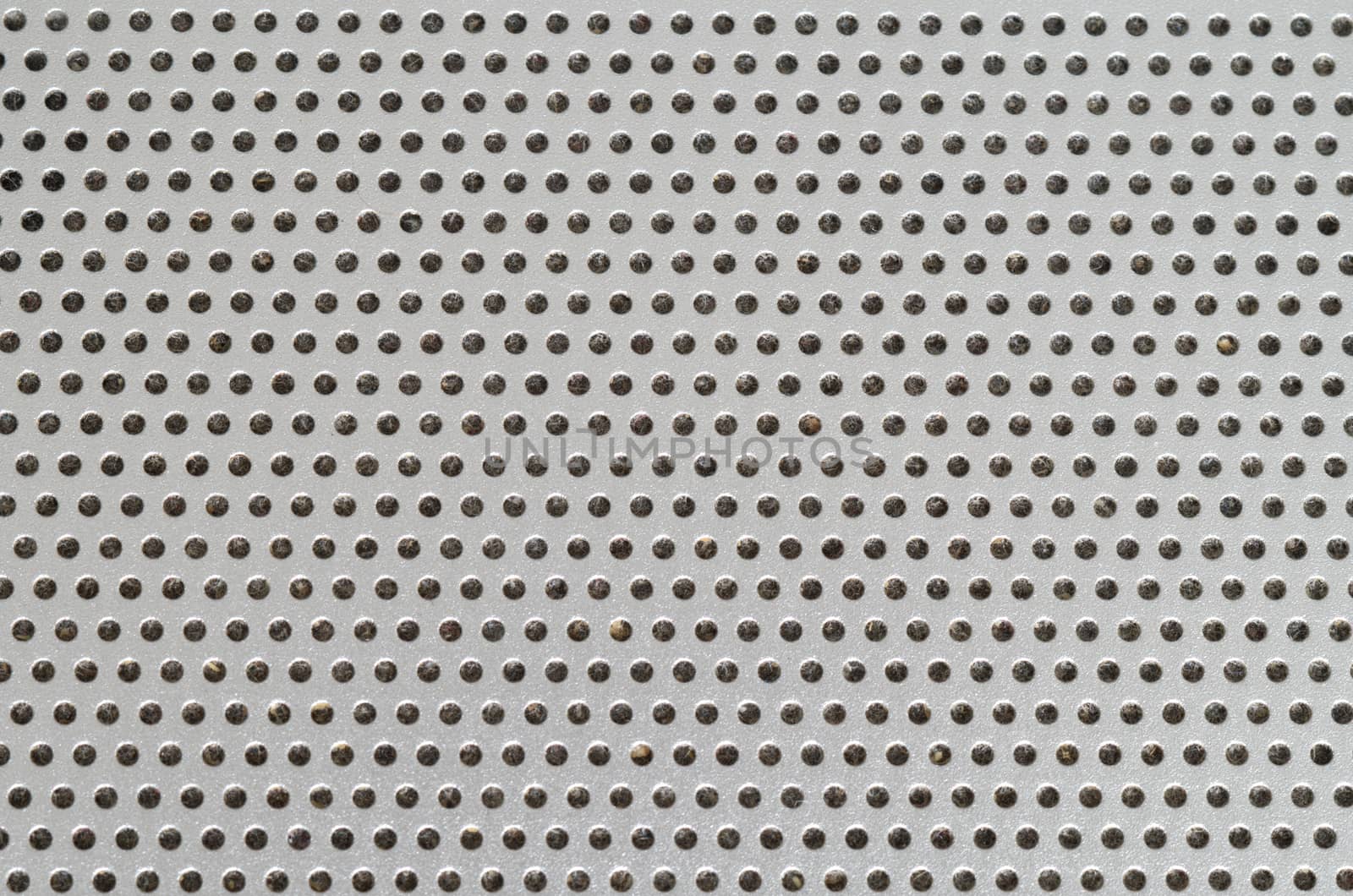 Laptop Speaker Hole grid metallic pattern macro with dust inside the holes