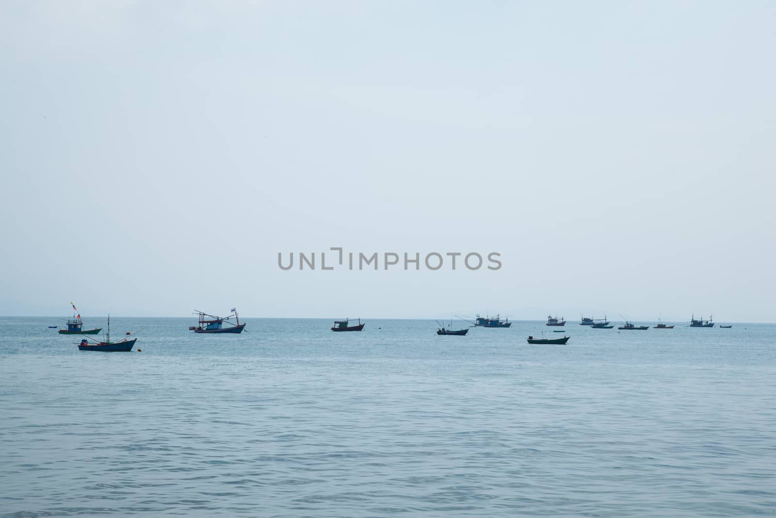 Small boat moored at sea. Small fishing boats moored offshore.