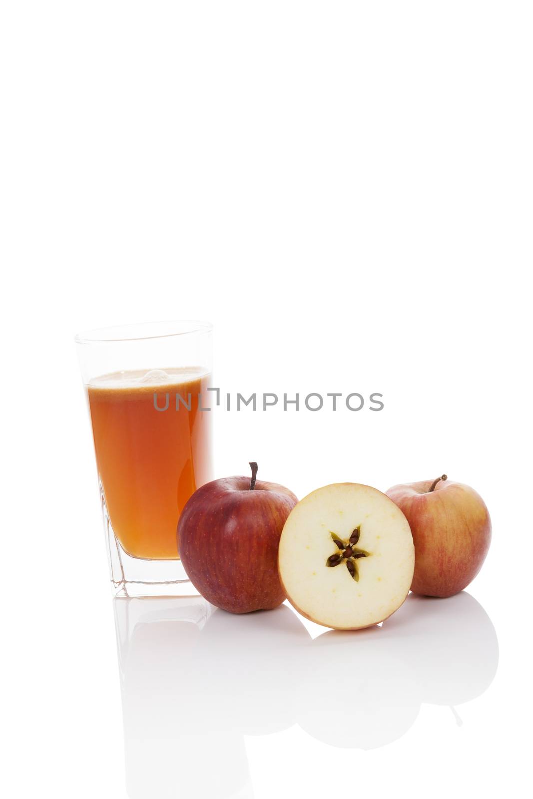 Delicious fresh healthy apple juice. Fresh ripe apples and juice in glass isolated on white background with reflection.