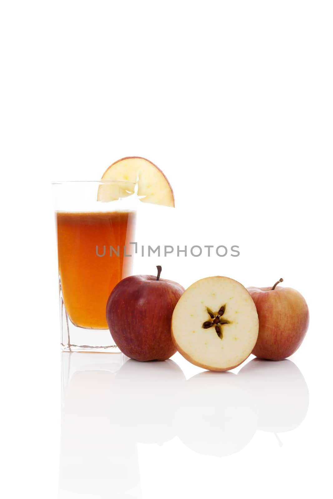 Fresh apple juice in glass with ripe apples isolated on white background with reflection. Luxurious healthy refreshing fruit juice. 