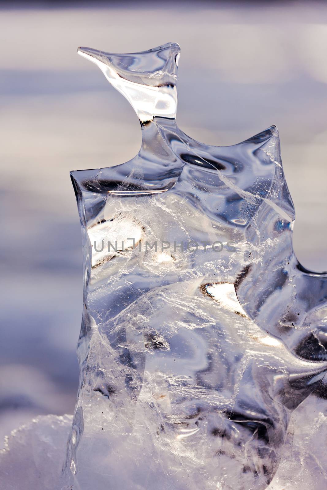 Light reflections in clear ice sculpture shaped by nature through repeated thaw and frost cycles