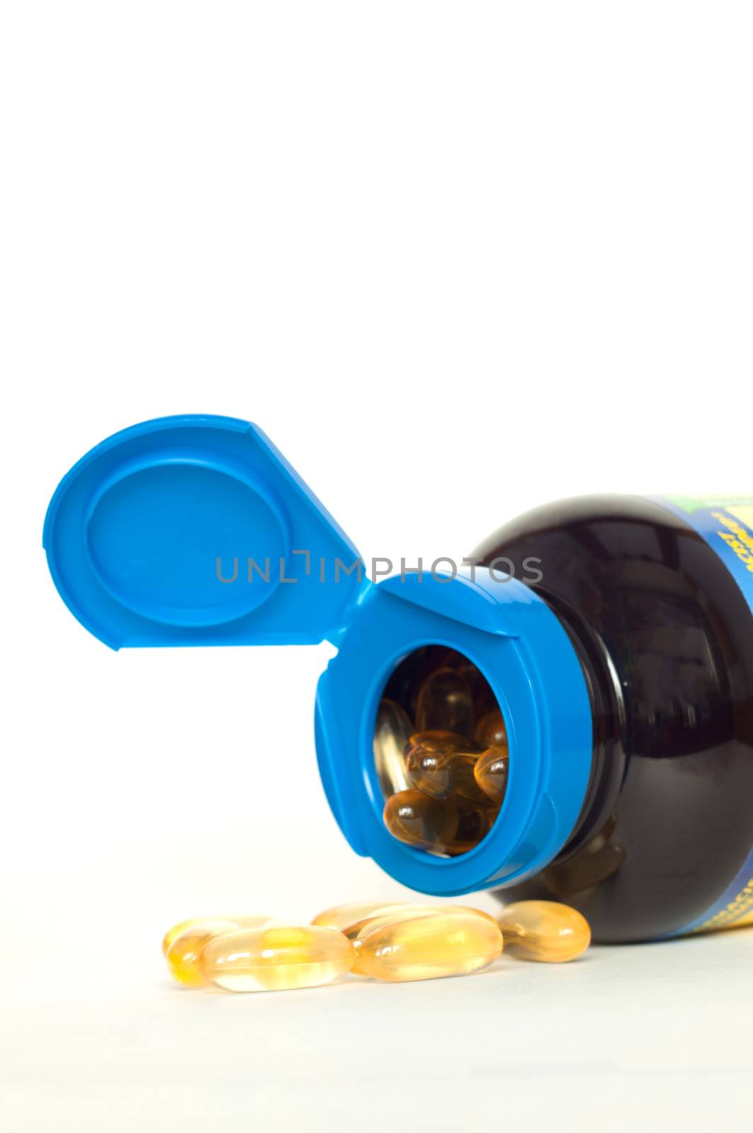 Open bottle of fish oil capsules on white background