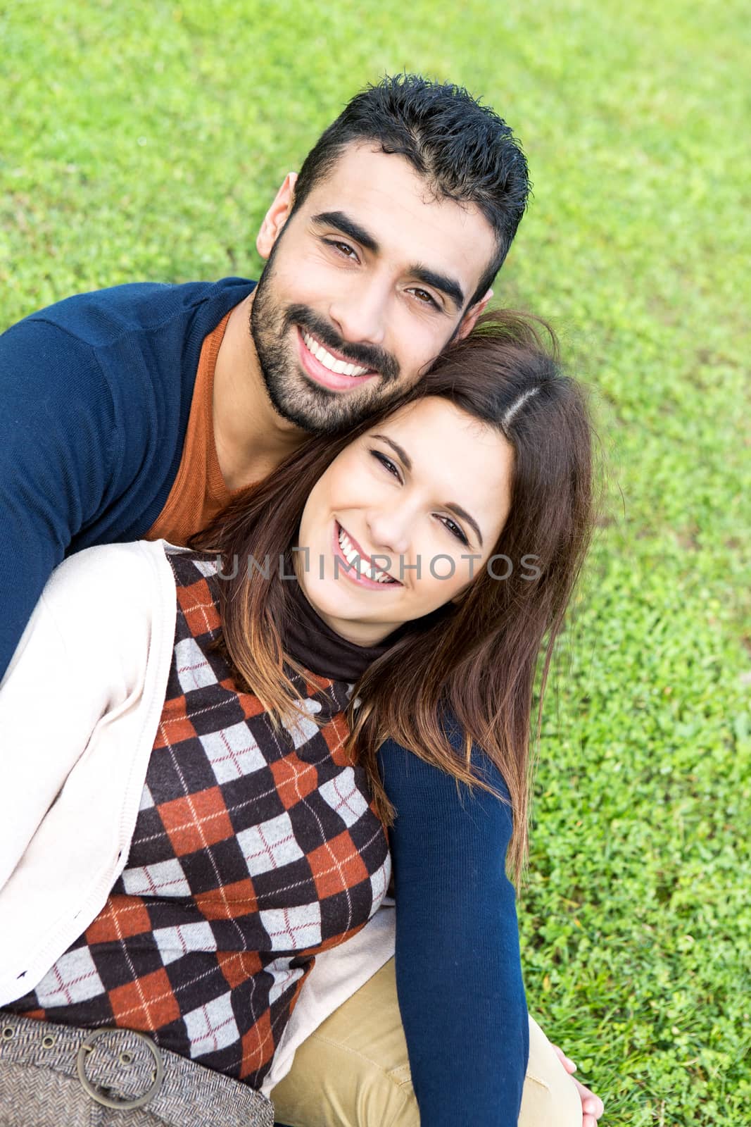 Happy couple relaxing on the grass park