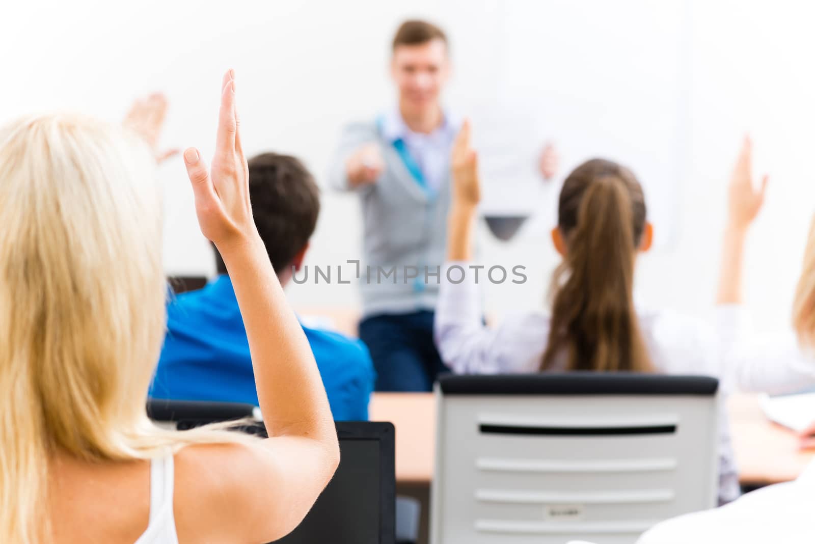 image of a female hand raised in university classroom