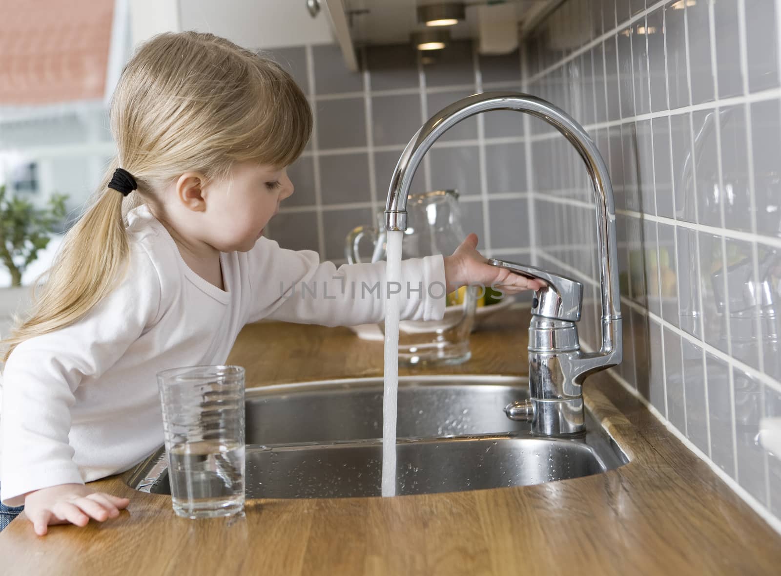 Small Girl in the kitchen drinking water